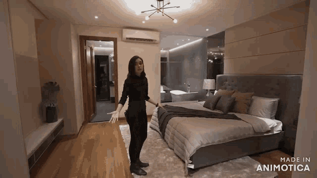 a woman is standing in a bedroom with the words made in animotica on the bottom right
