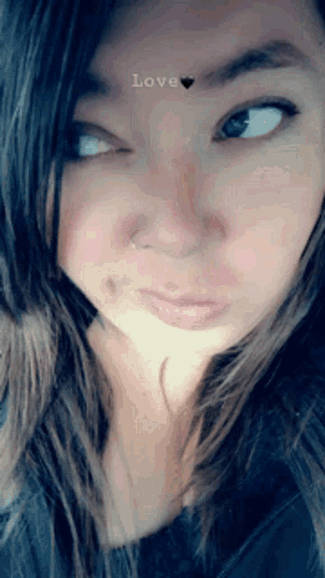 a close up of a woman 's face with the word love above her nose