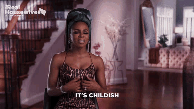 a woman in a leopard print dress is sitting in front of a staircase and says it 's childish
