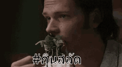 a man is eating a piece of food with a foreign language on the bottom .