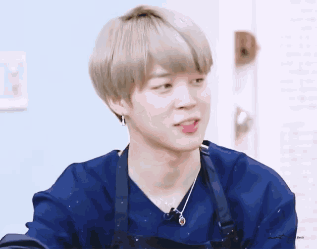 a close up of a person wearing an apron and a blue shirt