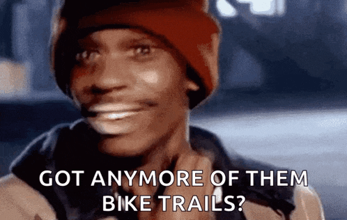 a man wearing a red beanie is smiling and asking if he has anymore bike trails .