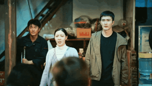 a man in a black shirt stands next to a woman in a grey jacket