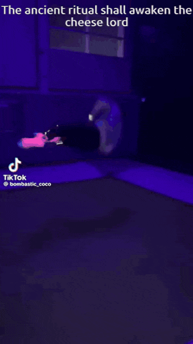 a person is laying on their back in a dark room with a purple background .