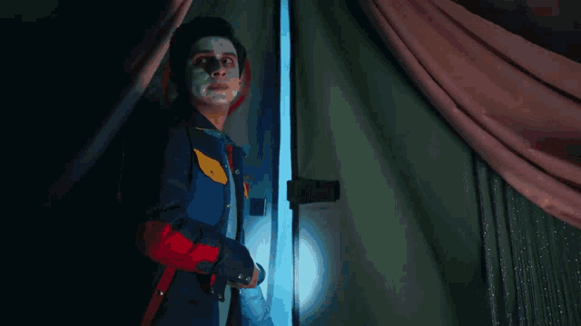 a person behind a green curtain that says no flame