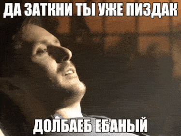 a man with a beard is laying down with a meme in russian