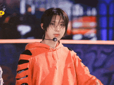 a person wearing an orange hoodie and a microphone
