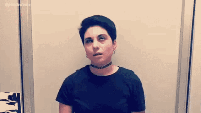 a woman with short hair and a choker is making a funny face .