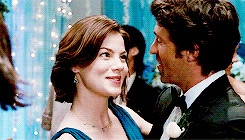 a man in a tuxedo and a woman in a blue dress are dancing