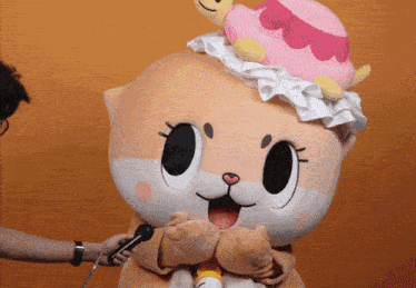 a person is holding a microphone next to a mascot