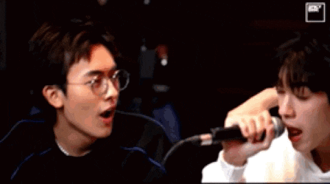 a man is holding a microphone next to another man 's face .