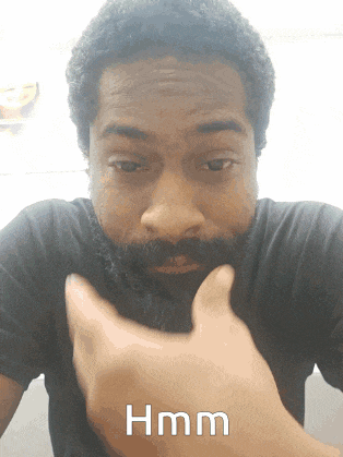 a man with a beard is giving a thumbs up with the word hmm written below him