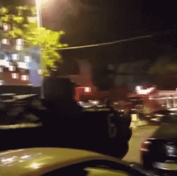 a blurry picture of a city street at night with a yellow car in the foreground