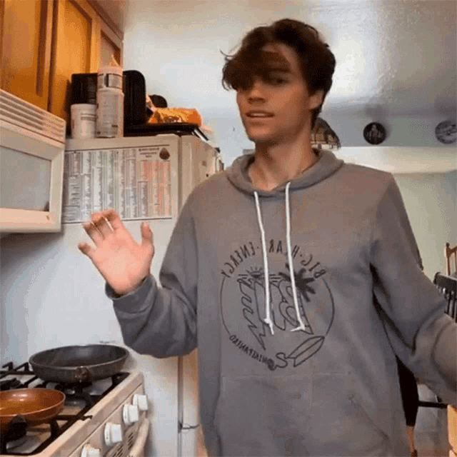 a young man wearing a grey hoodie that says ' dawn ' on it