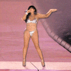 a woman in a bikini singing into a microphone on a stage