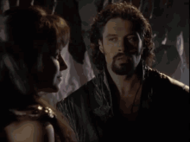 a man with a beard is talking to a woman who says " this "