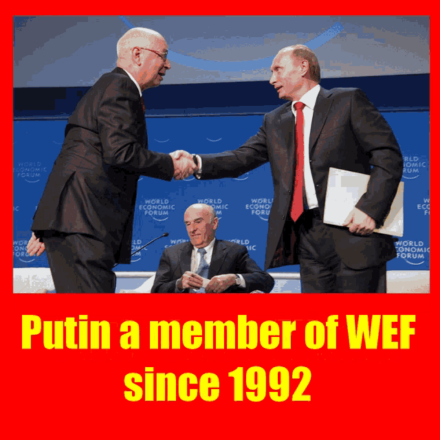 two men shaking hands in front of a world economic forum sign