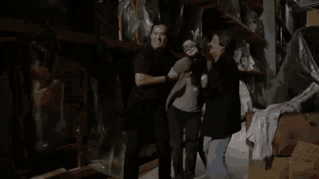 a man is holding a woman in a dark room .