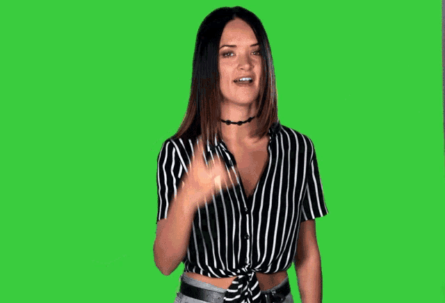 a woman in a black and white striped shirt is making a devil horns sign in front of the words fuck yeah