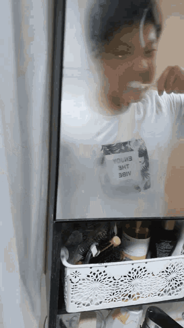 a person is brushing their teeth in front of a mirror with a t-shirt that says " vol3 " on it