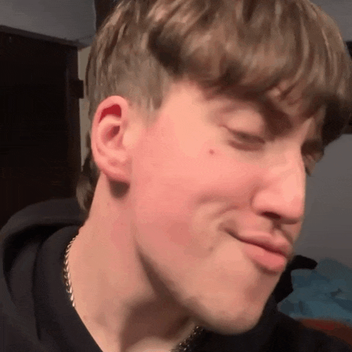 a close up of a young man 's face with his eyes closed and his mouth open .