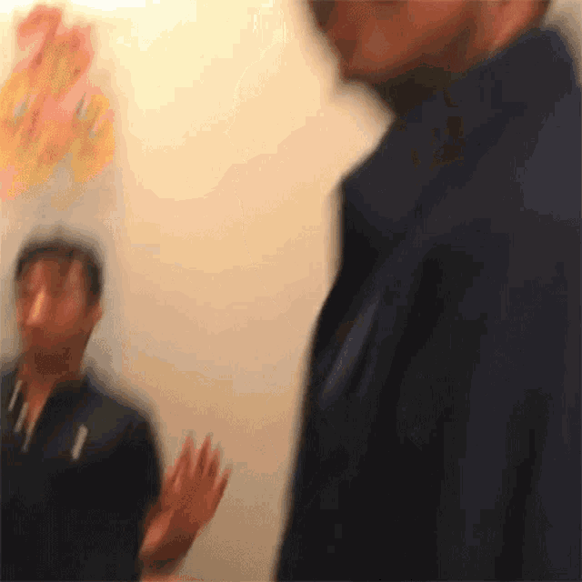 a blurry picture of a man wearing a polo shirt with the letter t on it