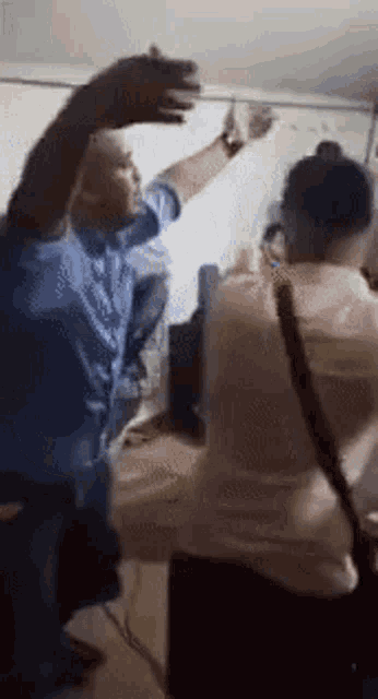 a group of people are standing around a table in a room with their hands in the air .