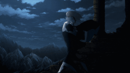 a woman in a black dress is standing in front of a mountain at night