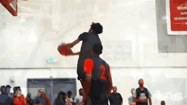 a basketball player with the number 2 on his back is jumping in the air