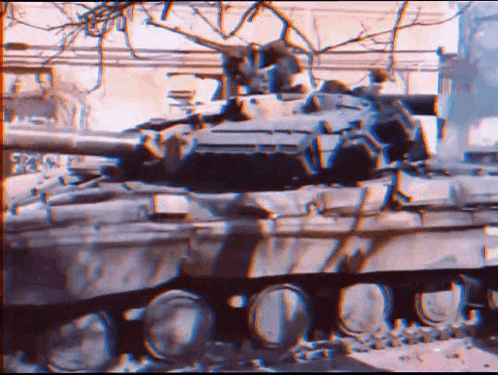 a tank is driving down a street in a city .