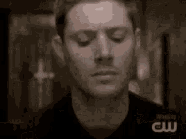 a close up of a man 's face with a blurred image of his hand .