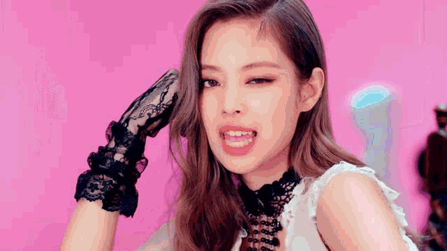 a woman wearing black lace gloves is making a funny face