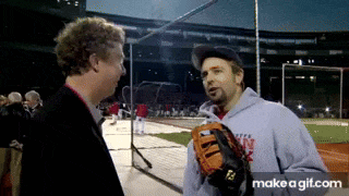 a man with a baseball glove is talking to another man on a baseball field .