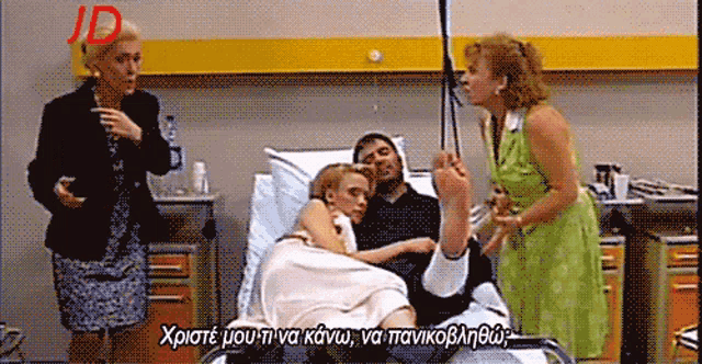 a woman in a green dress stands next to a man in a hospital bed with a woman in a white dress