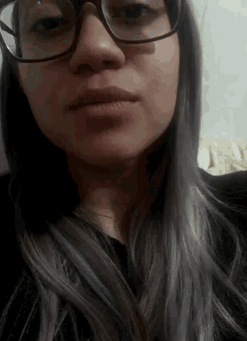 a close up of a woman 's face wearing glasses