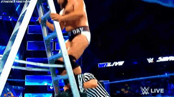 a wrestler is climbing up a ladder while a referee watches