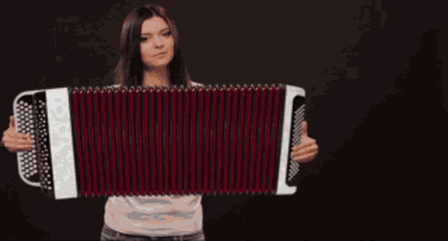a woman is holding an accordion in her hands