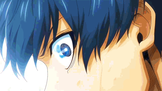 a close up of a person 's eyes with blue hair