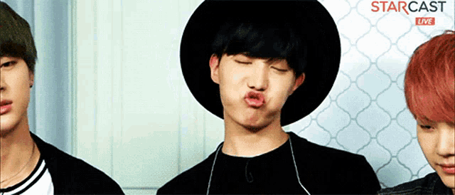 a man wearing a black hat is making a funny face