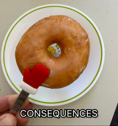 a person is holding a donut with a santa hat on it