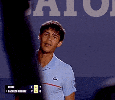 a man wearing a blue shirt with a lacoste logo on it