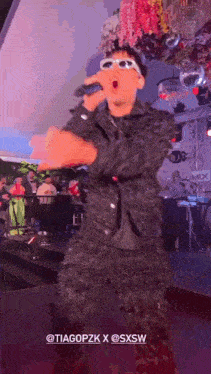 a man wearing sunglasses is singing into a microphone at a party