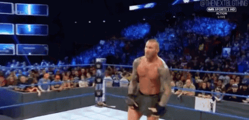 a man is standing in a wrestling ring with a sword in his hand ..