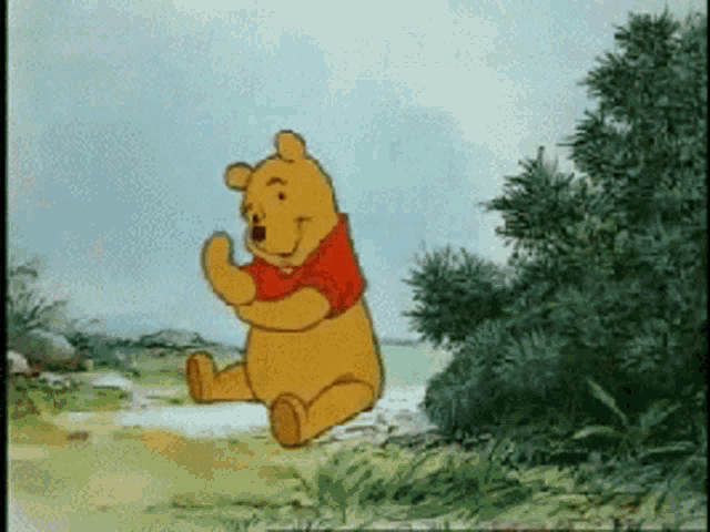 a winnie the pooh cartoon character is sitting in the grass