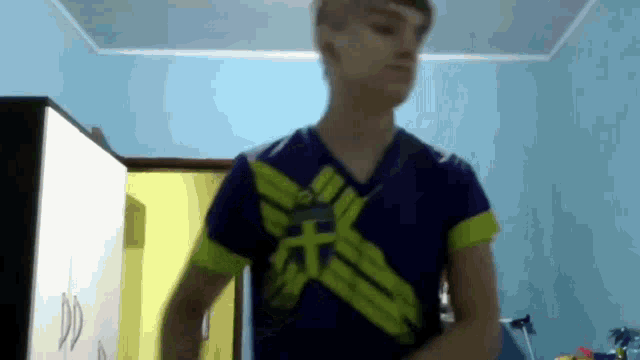 a young man is wearing a blue shirt with a yellow stripe on it .