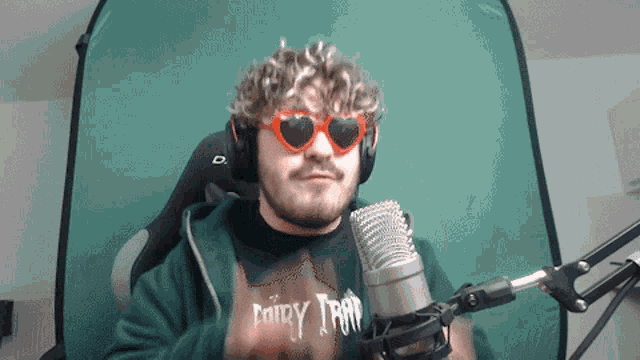 a man wearing sunglasses and a shirt that says dairy trap stands in front of a microphone