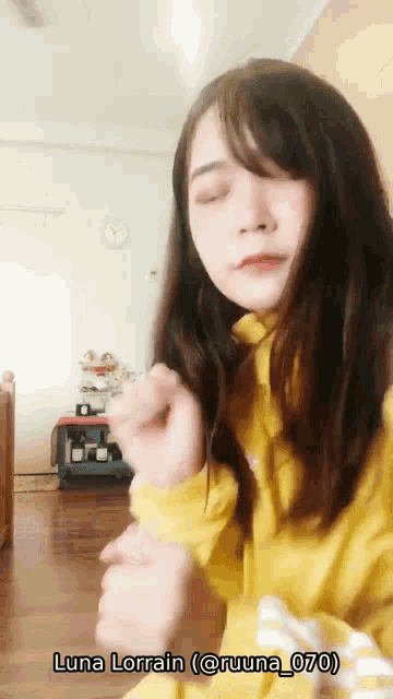 a woman in a yellow sweater with the name luna lorraine written on the bottom