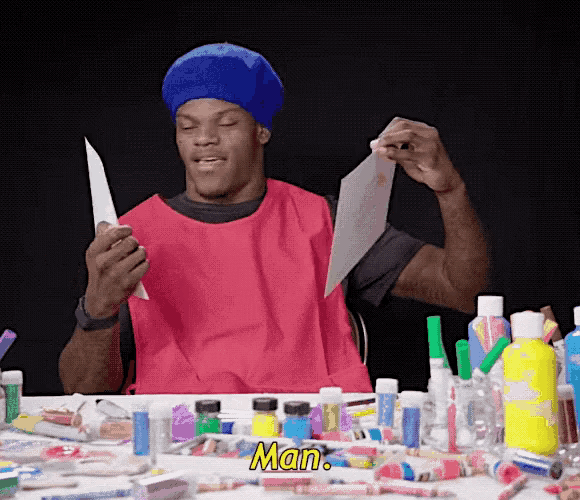 a man wearing a red apron and a blue hat is holding a piece of paper with the word man written on it
