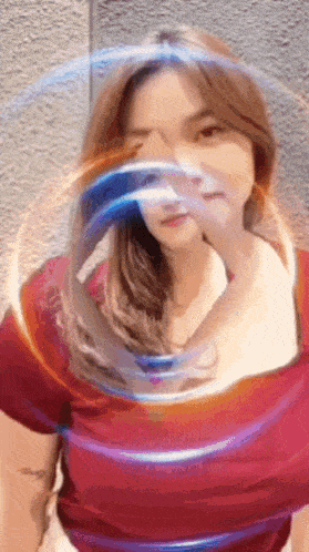 a woman in a red shirt covering her face with her hand
