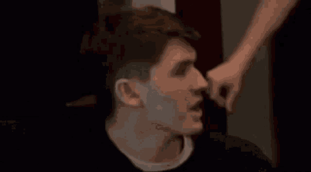 a man is being punched in the face by another man while sitting down .